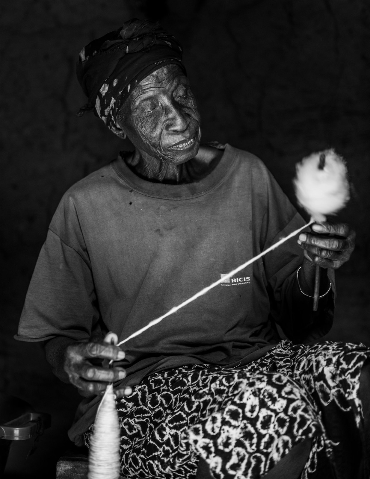 Femme filant du coton à la main selon une technique traditionnelle.