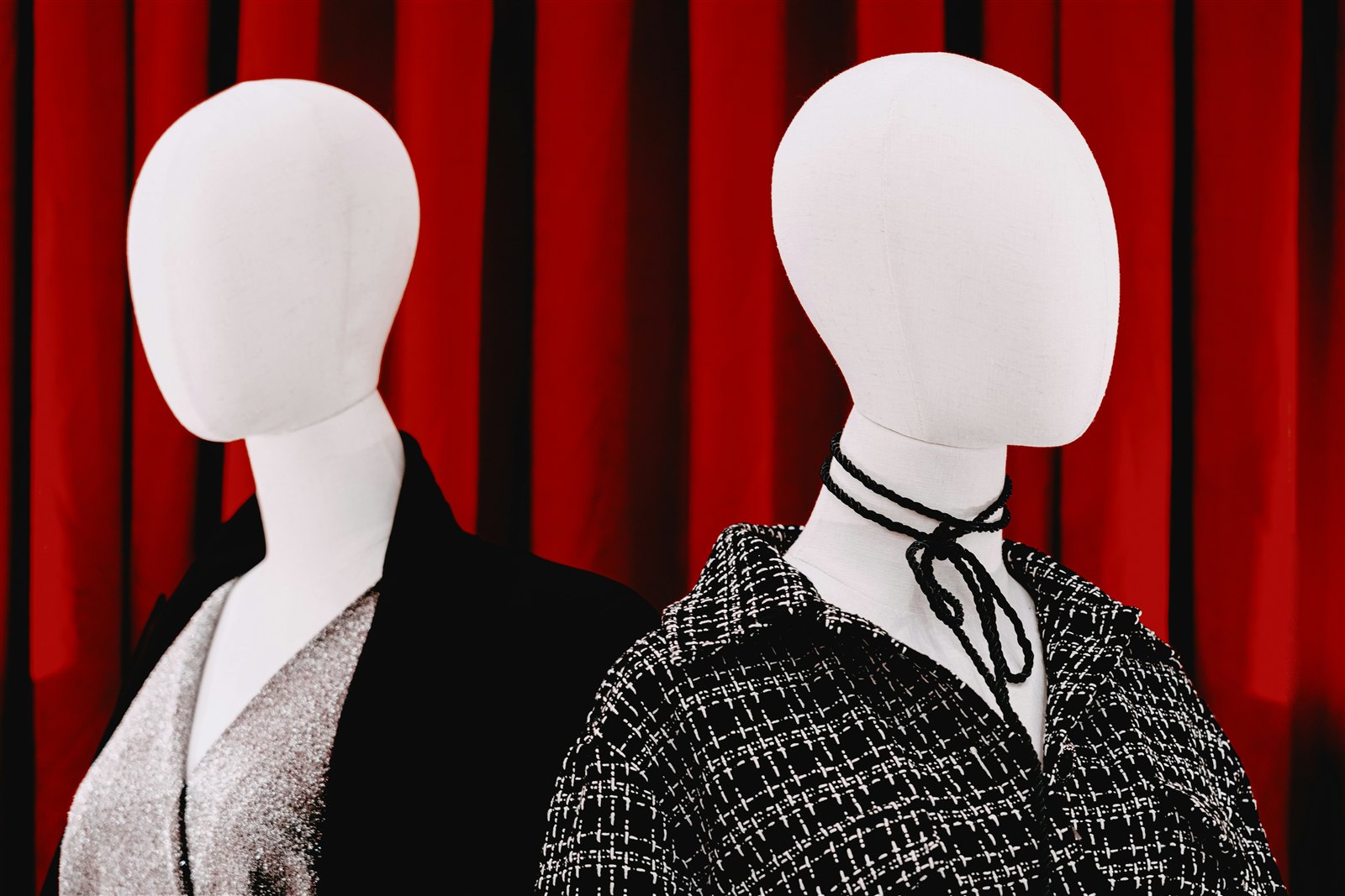 Mannequins de vitrine devant un rideau rouge, ambiance tapis rouge.